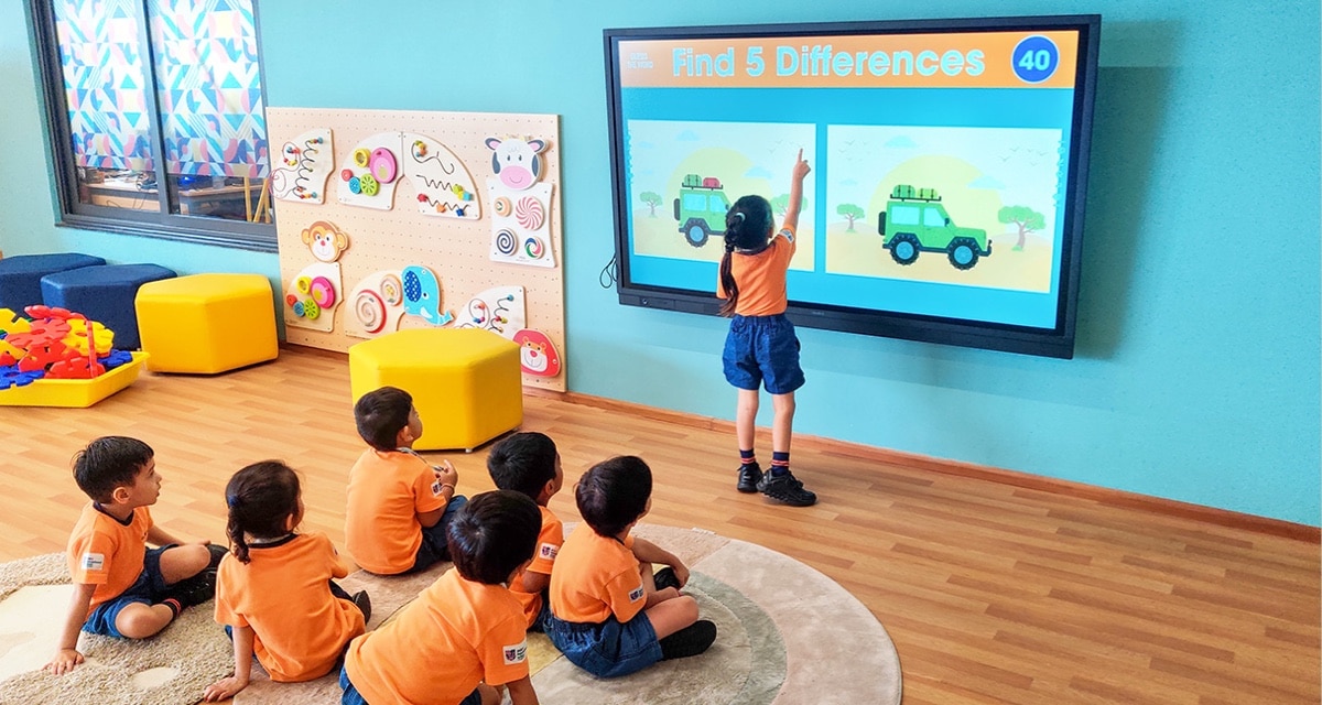 a student showing image on monitor to other students in a classroom