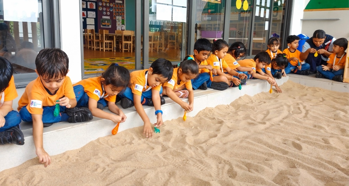 students doing sand activity at Adani international School