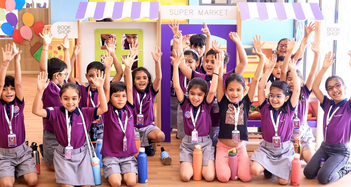 students with raising hand at Adani international School