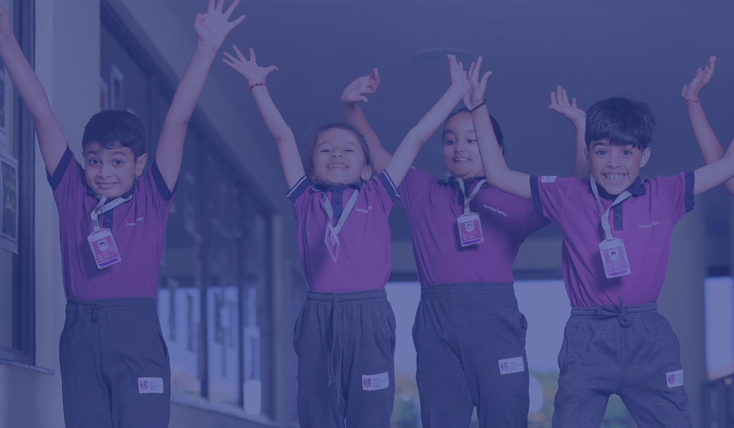 a group of students with raising hands at Adani International School