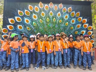 students standing in front of a wall at Adani International School