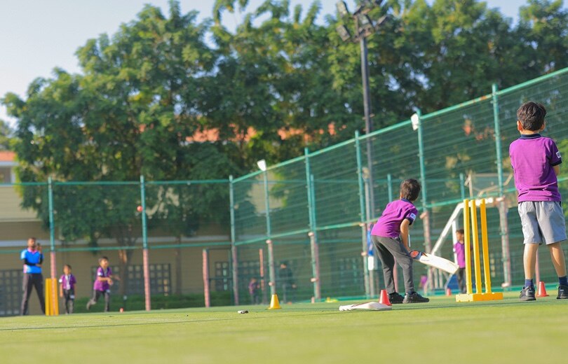 students in a net cricket ground at Adani International School