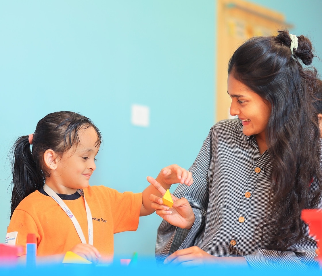 girl student with teacher in a classroom at adani international school