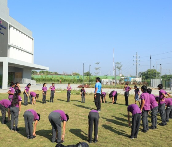 students with sports teacher at Adani international School