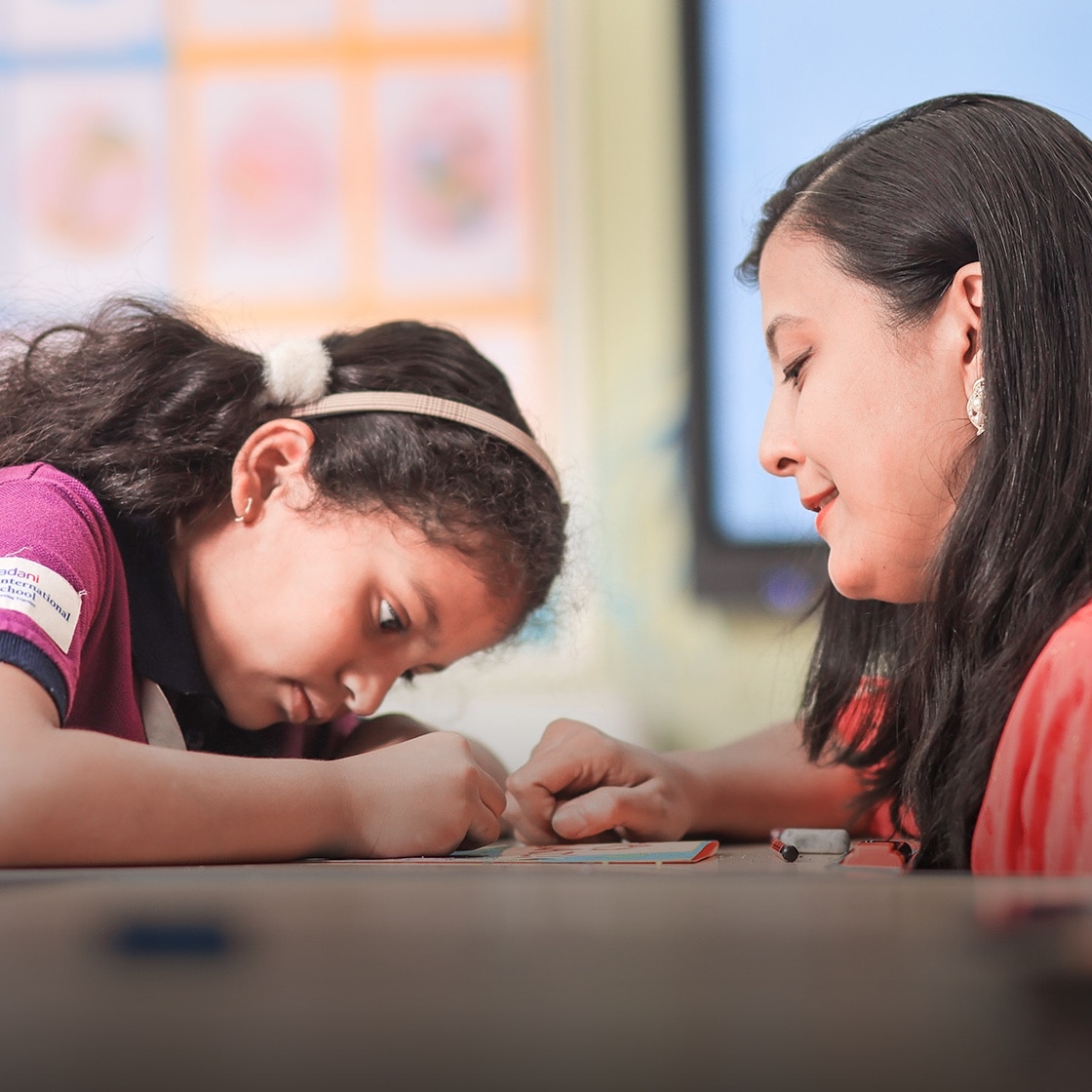 student & teacher in a classroom at Adani International School