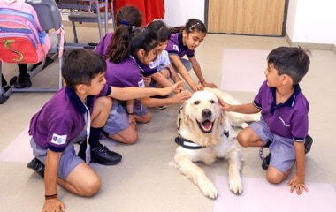 students & teachers with the dog at Adani International school