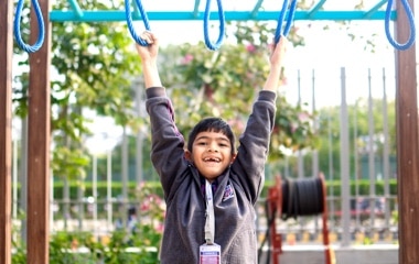 student swinging in a playground